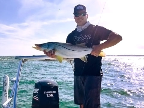 Captain Donald Andrezze holding a fish on the water